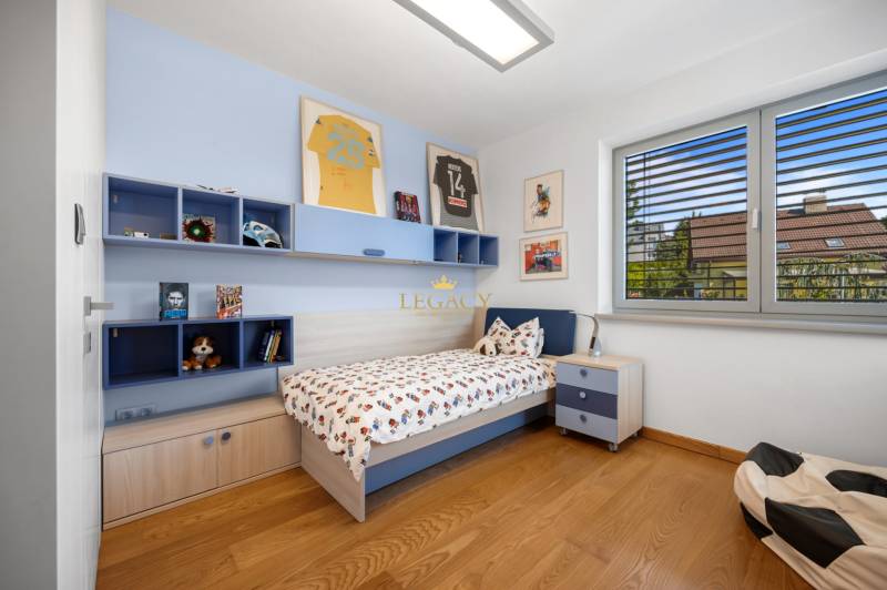 A children's room in a family house with a bed, shelves, pictures, and modern furnishings.