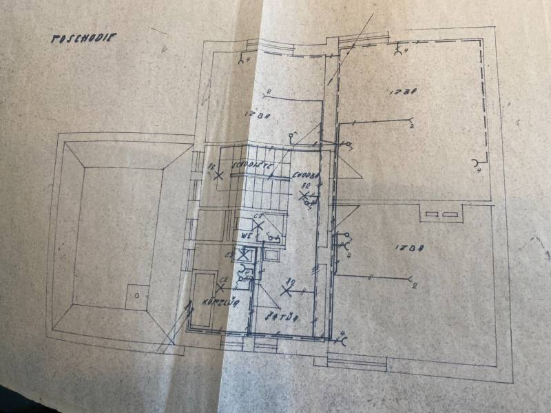 Floor plan of a family house with rooms and staircase. Warm paper tones.