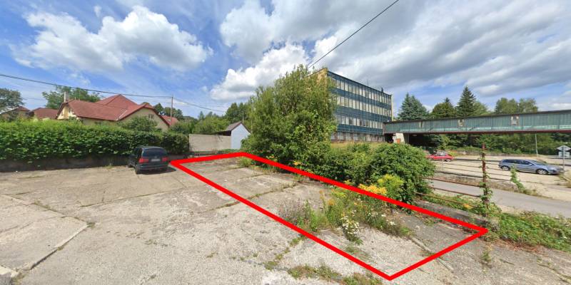 Commercial land in Handlová on Štrajková, next to the parking lot and administrative buildings.