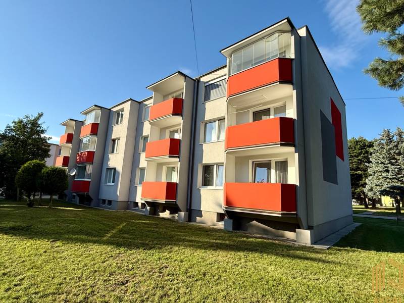 The exterior of an apartment building on the Sídlisko in Jablonica with red balconies.