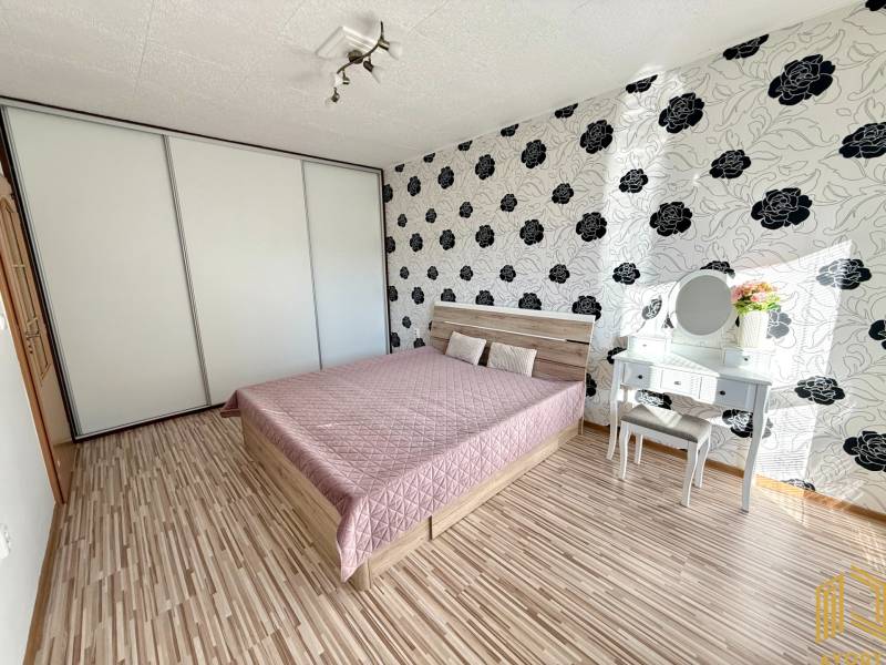 Bedroom in a 2-room apartment with a bed, built-in wardrobe, and dressing table.