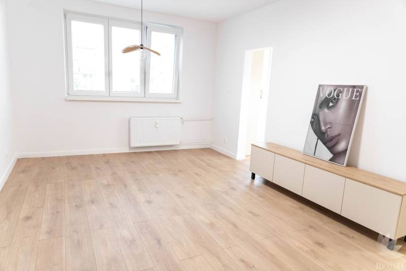 A bright room in a 2-room apartment with wooden flooring and decoration.