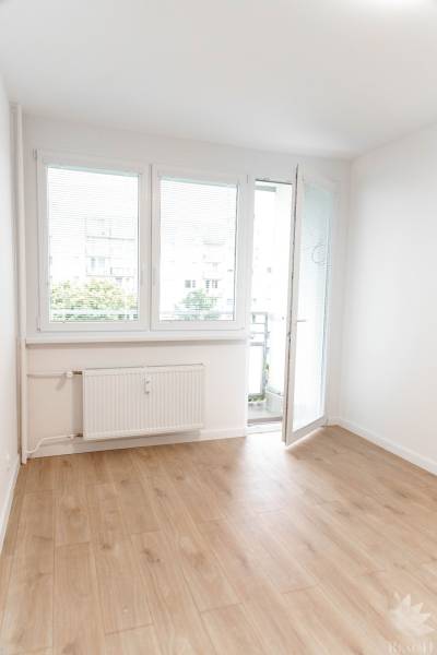 In the 2-room apartment, there is a bright room with balcony doors and a wooden floor.