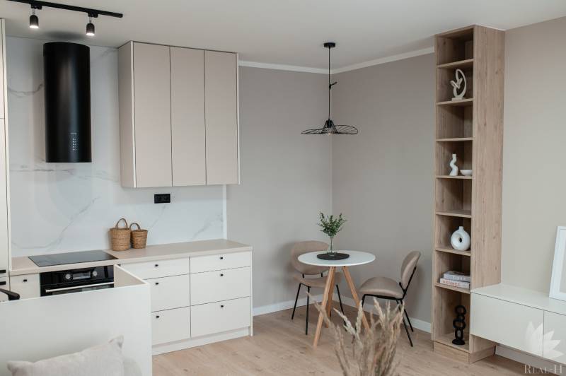 A kitchen with a dining table and a built-in shelf in a 2-room apartment.