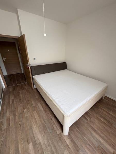 Bedroom in a 2-room apartment with a bed and wooden floor, the door leads to the hallway.