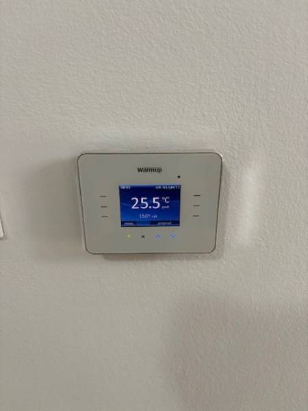 The digital thermostat displays the current temperature in a 2-room apartment.