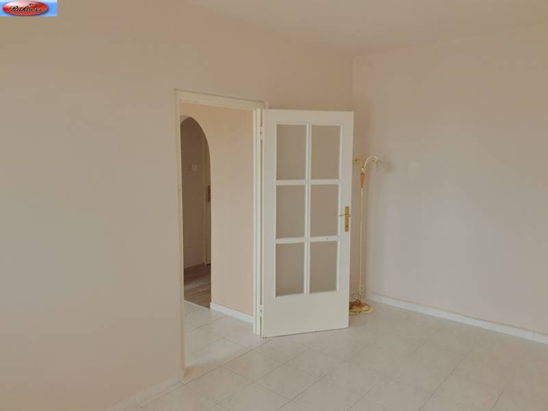 Tiling in a 3-room apartment, white doors with glazing, and a floor lamp.