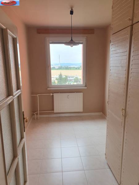 A small room in a 3-room apartment, wardrobes, window with a view, radiator.