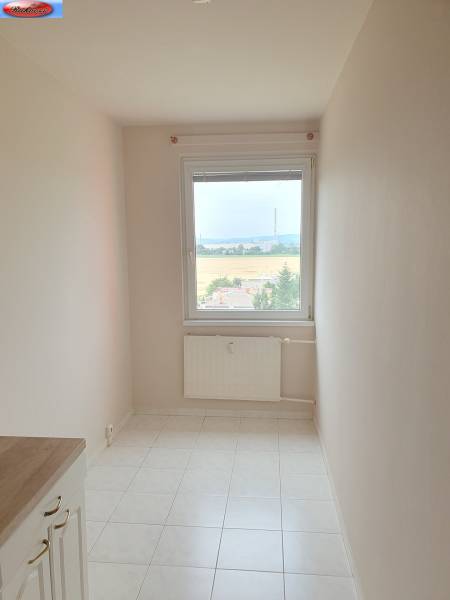Narrow room with a window and tiled floor in a 3-room apartment.
