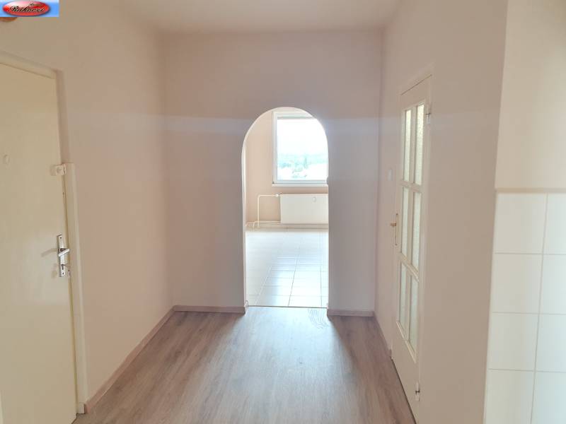 A corridor with an arched passage and flooring in a 3-room apartment.