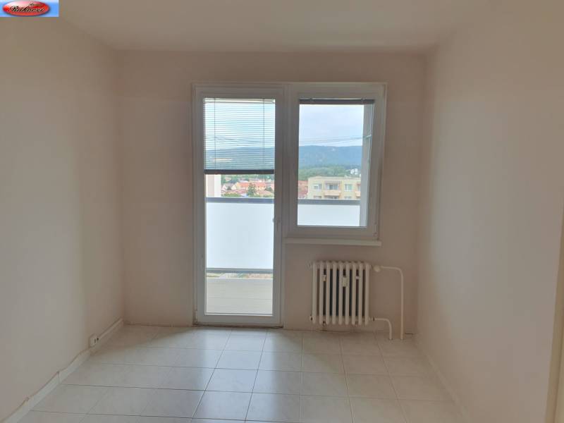 A room in a 3-room apartment with tiles, a radiator, and a balcony door.