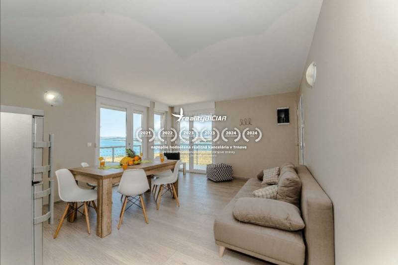 Bright living area with a dining table in a holiday apartment with a sea view.