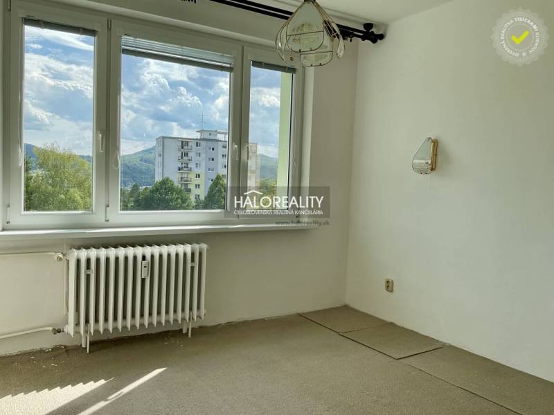 A room in a 3-room apartment with a view of nature and the neighboring apartment building.