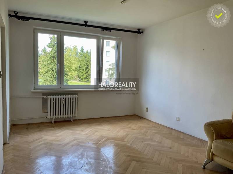 A room with a light parquet floor and a large window in a 3-room apartment.