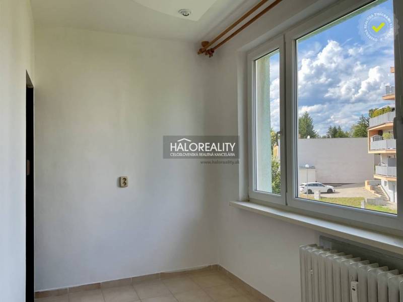 Interior of a 3-room apartment with white walls and a view from the window of Zvolen.