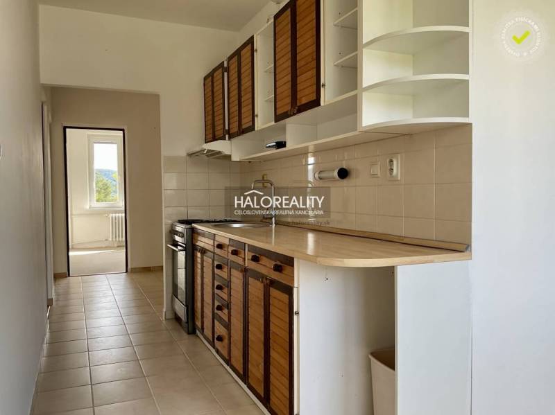 A kitchen in a 3-room apartment with wooden cabinets and a stove.