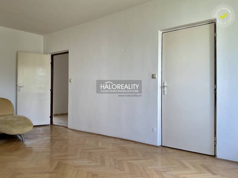 A room in a 3-room apartment with parquet flooring and white doors.