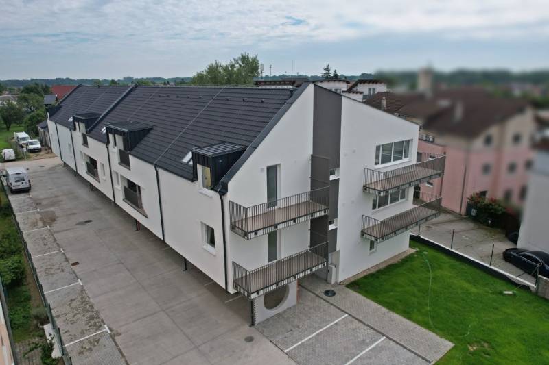 Apartment complex on Muškátová Street in Zálesie with parking spaces and minimalist architecture.