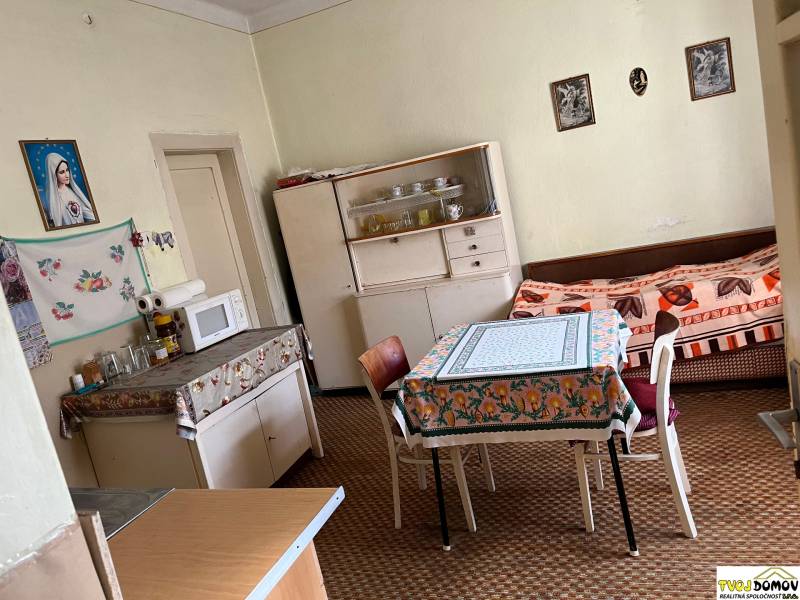 Kitchen in a family house with a dining table, microwave, and sofa.