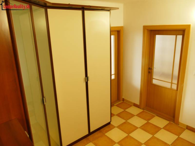 A hallway in a 3-room apartment with a large built-in wardrobe and doors with frosted glass.