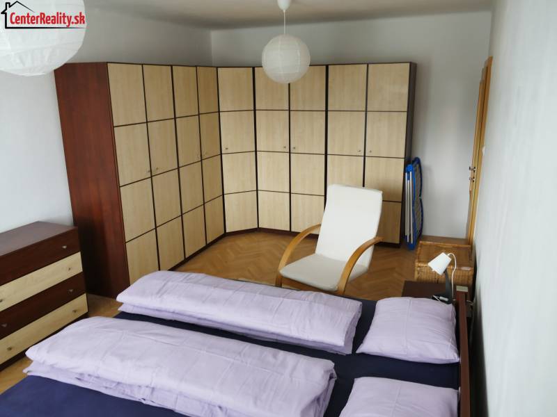 A bedroom in a 3-room apartment with a large corner wardrobe and an armchair.