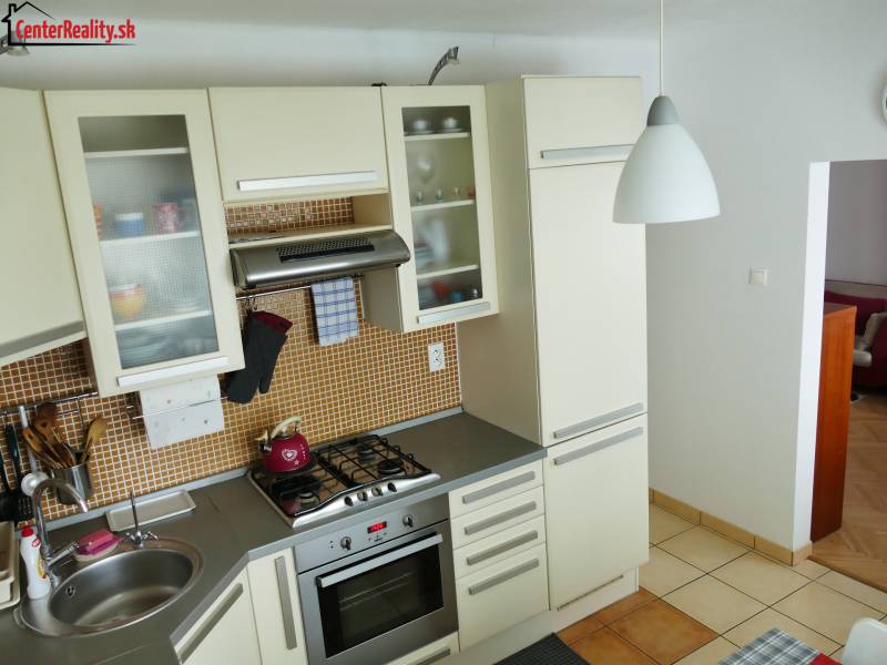 A kitchen in a 3-room apartment with a corner sink and a gas stove.