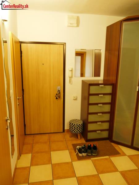 Entrance hall in a 3-room apartment with tiles and storage space, visible mirror.