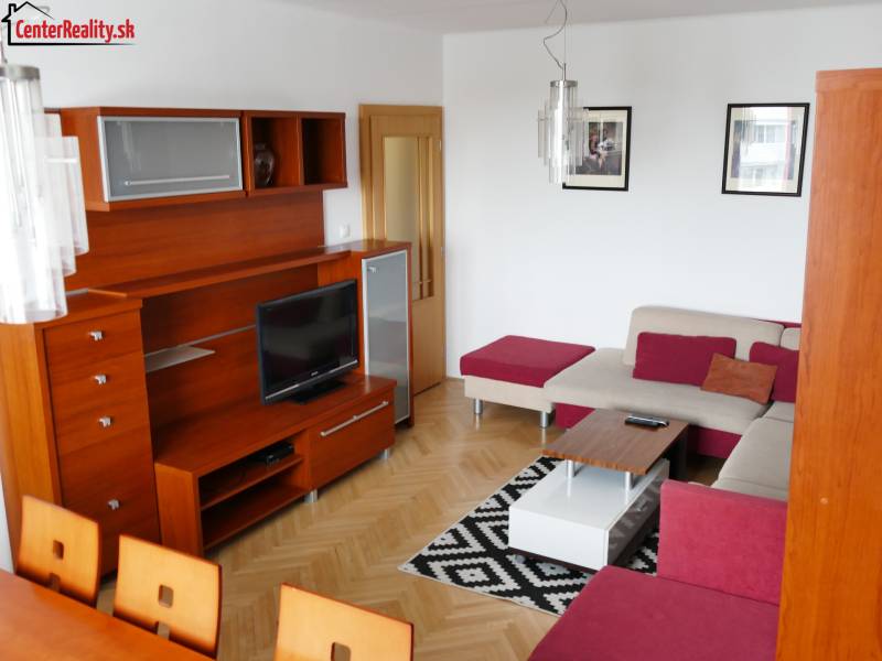 Living room in a 3-room apartment with a wooden wall unit and a corner sofa set.