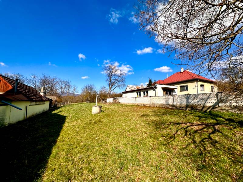Construction of houses in Moravské Lieskové, spacious yard with lawn, blue sky.