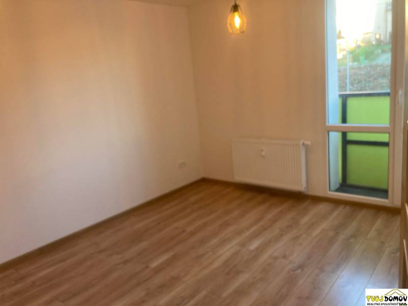 A room with a light floor, a radiator, and balcony doors in a 3-room apartment.