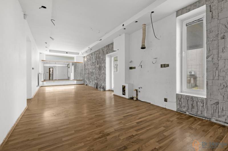 Spacious commercial premises with wooden flooring and mirrors on the wall.