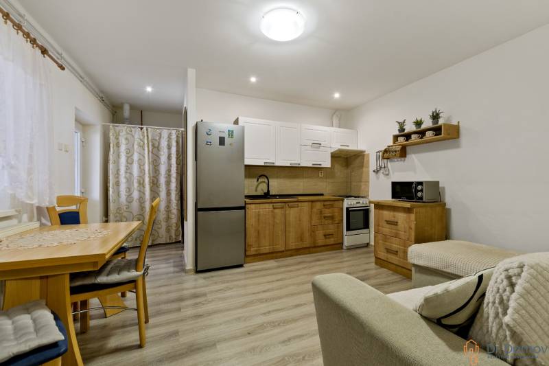 The kitchen and dining room in a 2-room apartment with wooden elements and furnishings.