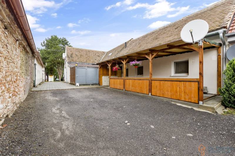 Courtyard space at a 2-room apartment in Malé Leváre with paving and a wooden pergola.