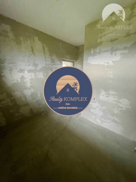 An unfinished room in a family house with unfinished plaster and a concrete floor.