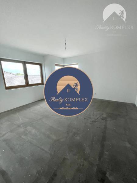 An empty room with a gray floor and two windows in a family house.