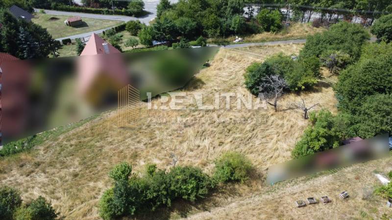 Building plots - housing in Banská Štiavnica on SNP, surrounded by grass and trees.