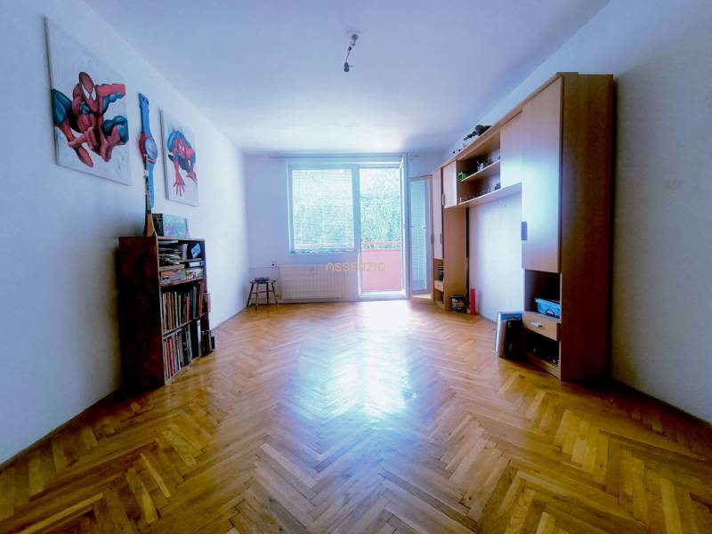 Living room in a 3-room apartment with parquet flooring, furniture, and wall decorations.
