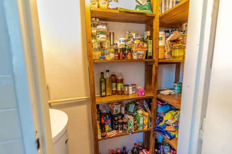 A pantry with shelves full of food in a 4-room apartment.