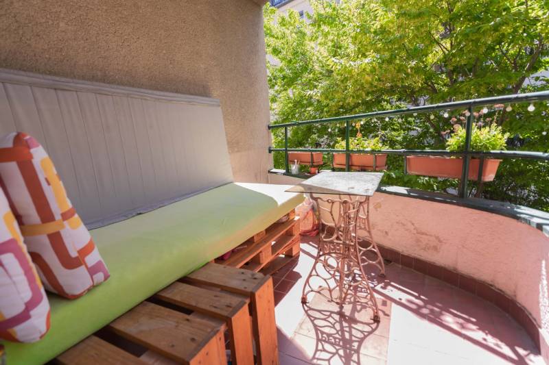 A balcony with wooden pallets and a metal table in a 4-room apartment.