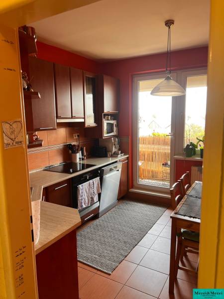 A kitchen with wooden cabinets and a dining area in a 3-room apartment.