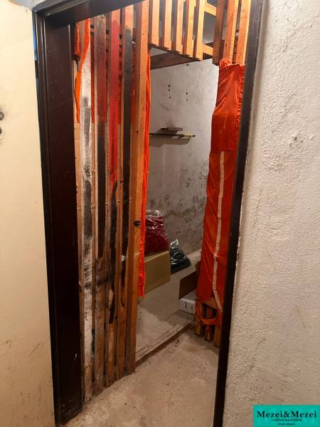 Small room with a shelf, boxes, and curtains, part of a 3-room apartment.