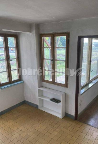 Interior of a family house with large windows and a simple shelf.