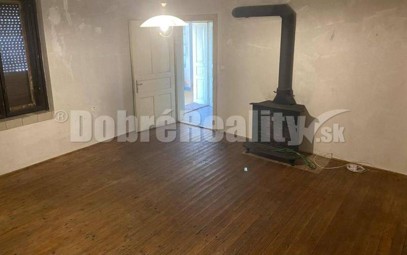 A room with a wooden floor and a tiled stove in a family house, simple interior.