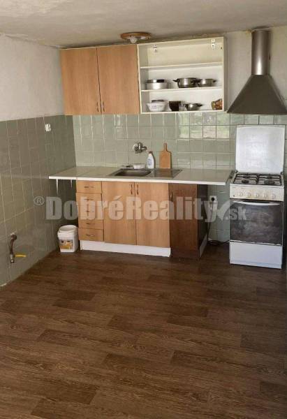 A kitchen in a family house with a stove, countertop, cabinets, and a range hood.