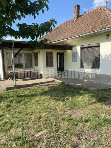 A family house in Mojmírovce on Mojmírovce Street with a lawn and a tree in the garden.