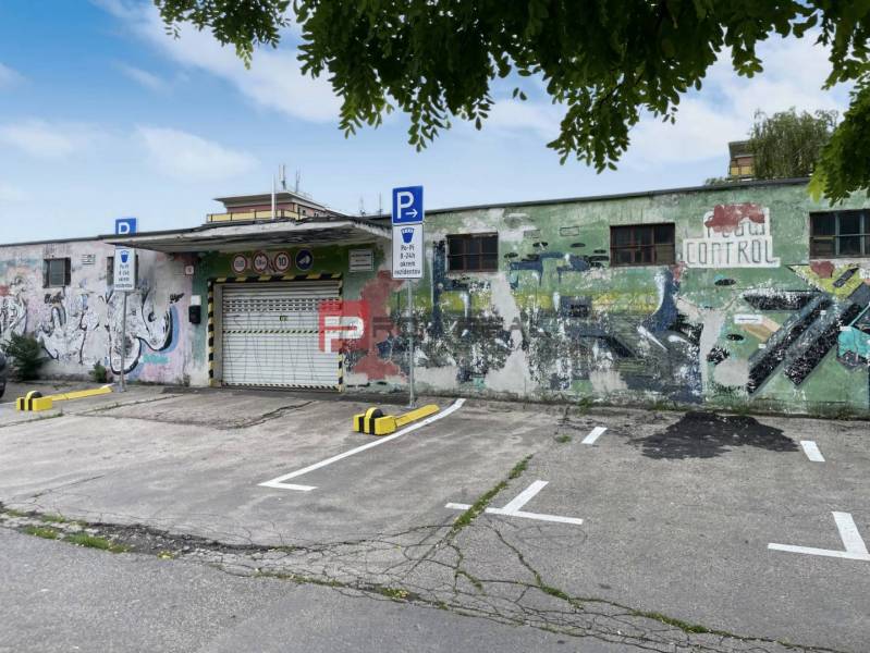 Garages on Pionierska Street in Bratislava III with graffiti and a parking lot.