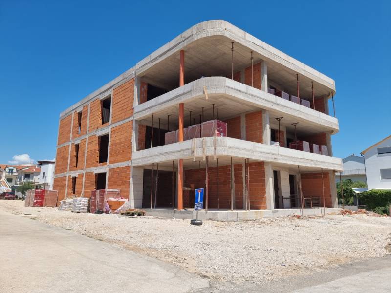 An unfinished building with a 3-bedroom apartment in the town of Vodice on a sunny day.