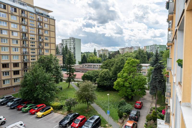 View of a residential block, greenery, and a parking lot in Košice, Sever district, on Božena Němcová Street.