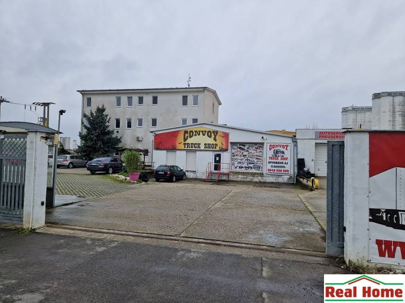 Convoy Truck Shop building on Šamorínska Street, surrounded by parked cars near the warehouse and halls.
