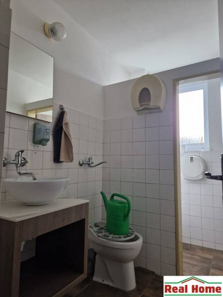 Bathroom with a sink, toilet, and showerhead. Warehouses and halls on Šamorínska Street.